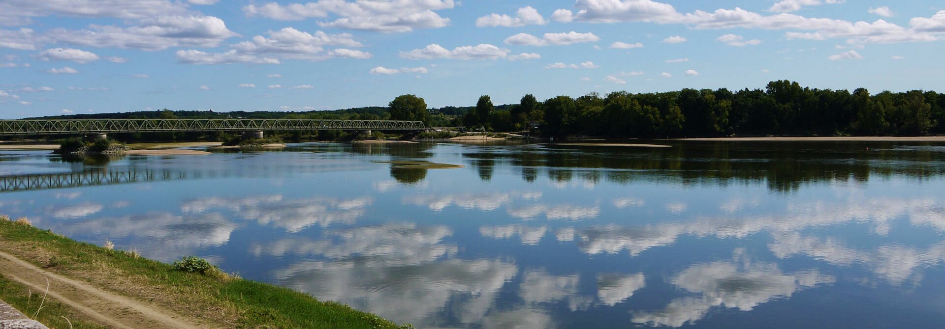 La Loire sous un ciel nuageux, avec ses berges et un pont
